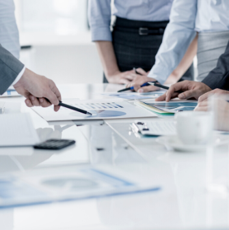 People pointing at documents on a desk