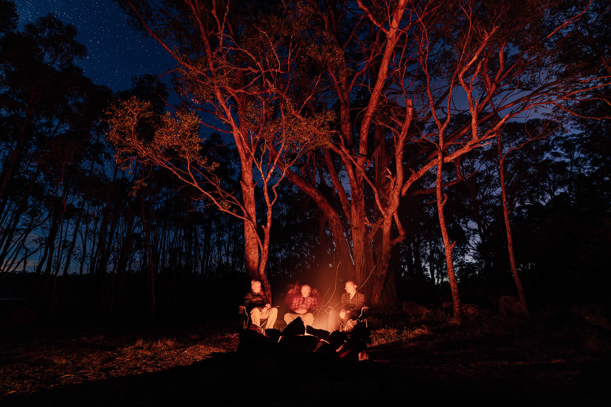 People sitting around a campfire after a day of fishing at Penstock Lagoon