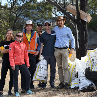 A group of employees participating in Clean Up Australia Day with sacks of rubbish they have collected